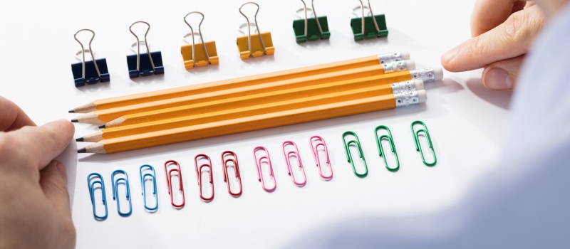 Businessman Arranging The Pencils In Between Colorful Pins